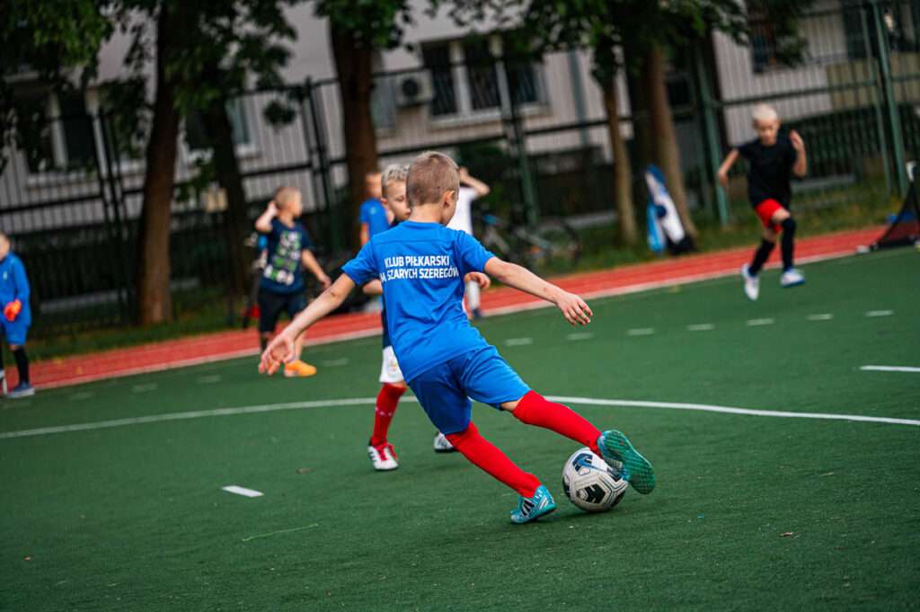 Dzieci trenujące piłkę nożną w Klubie Szare Szeregi